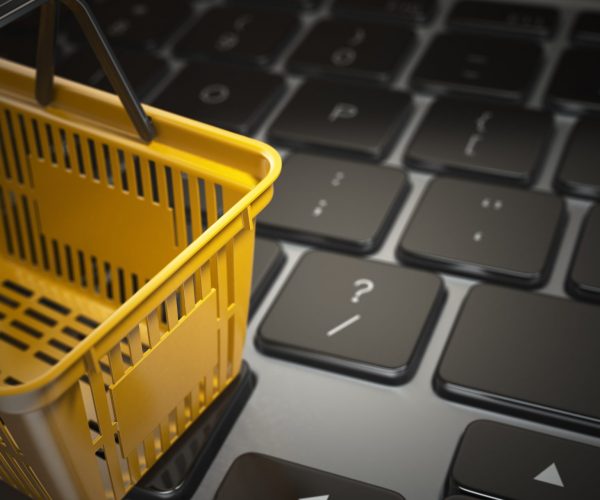E-commerce, online shopping, internet purchases concept. Yellow E-commerce, online shopping, internet purchases concept. Yellow shopping basket on computer laptop keyboard, 3d illustration